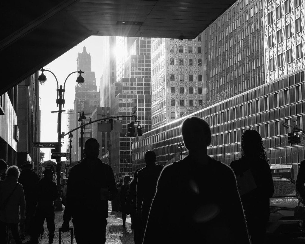 Pedestrians in silhouette on Lexington Avenue at sunset, midtown towers catching the last light