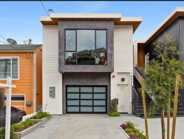 Exterior photograph of the matched property: a two-storey house with a flat roofline, a dark upper window bay, and a glazed garage door